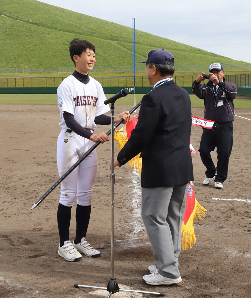 優勝旗を手に取り笑顔を見せる二瓶主将（旭川大雪ボーイズ）