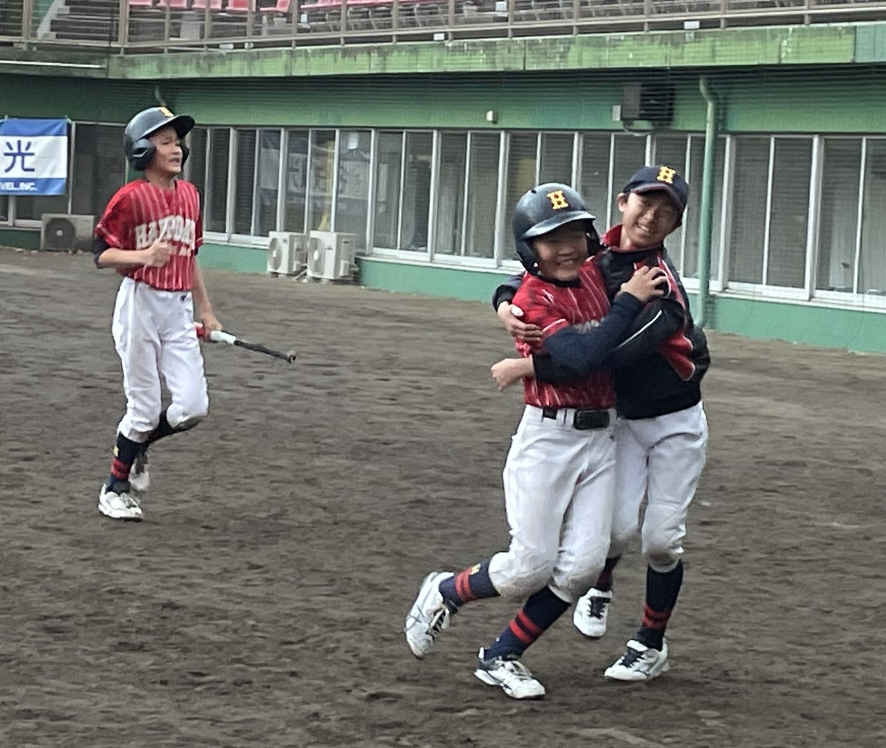 五回、勝ち越し打を放つ吉田と抱き合う松澤。写真左は生還した渡辺。