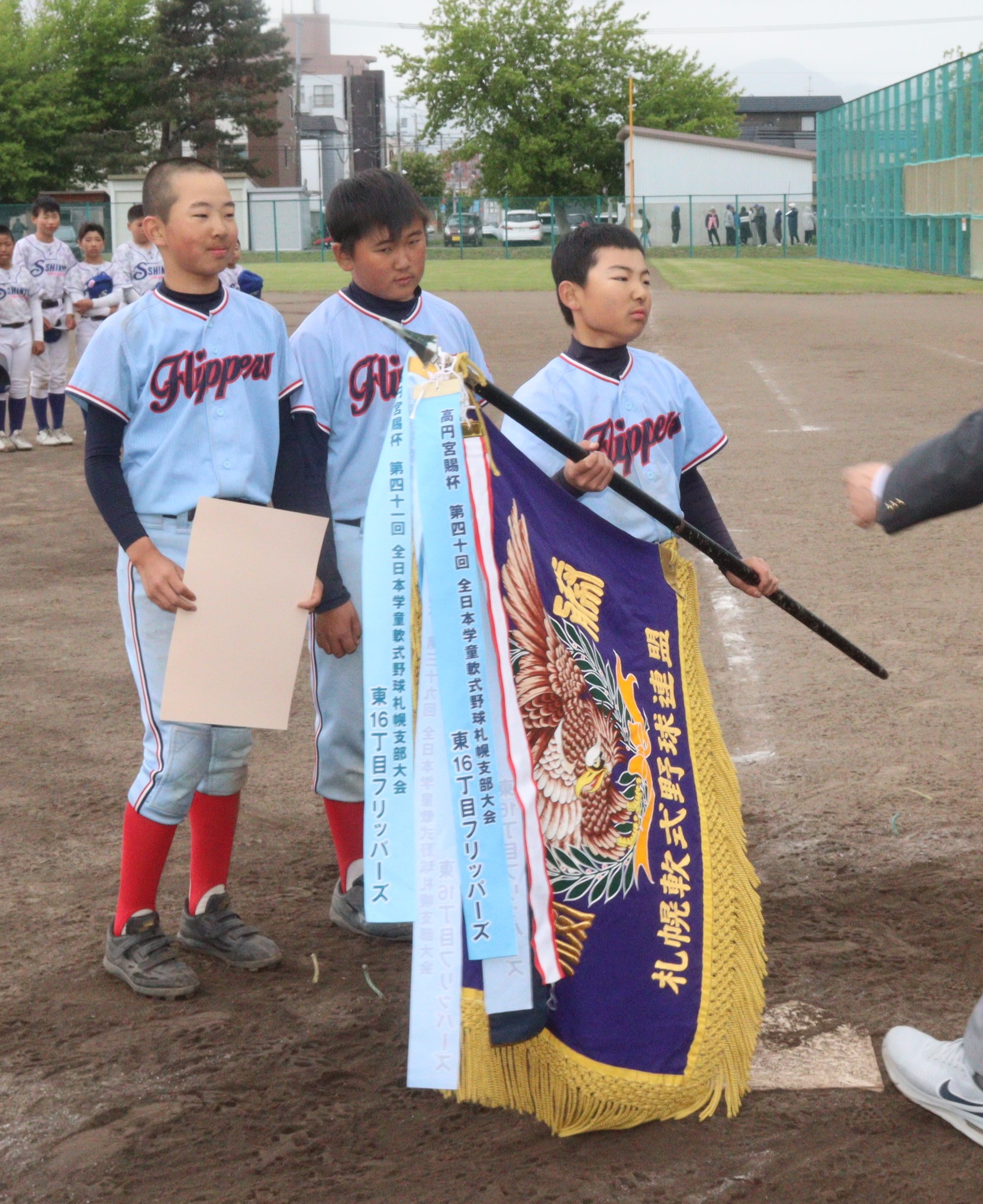 優勝旗を手に取る小野寺主将（東16丁目）