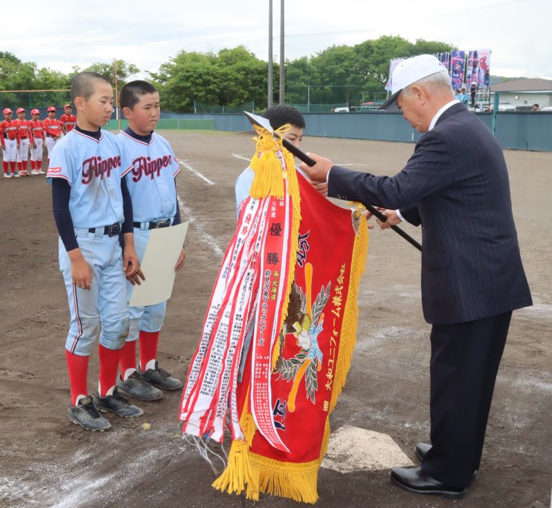 しっかりと優勝旗をつかむ小野寺主将（東16丁目フリッパーズ）