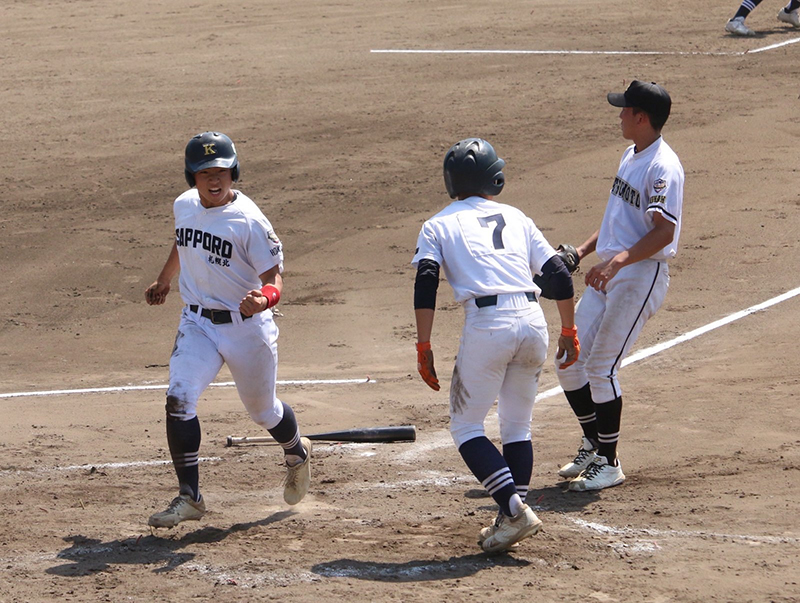 写真左　藤田が三盗を決め、相手バッテリーのミスで同点のホームを踏む。
