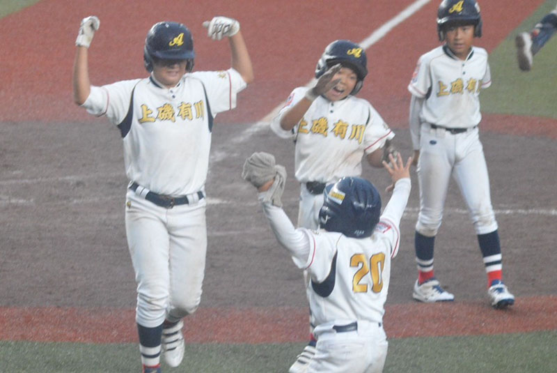 不調を吹き飛ばすランニング本塁打を放ち、笑顔で生還する主将・佐藤を歓喜で迎えるチームメート