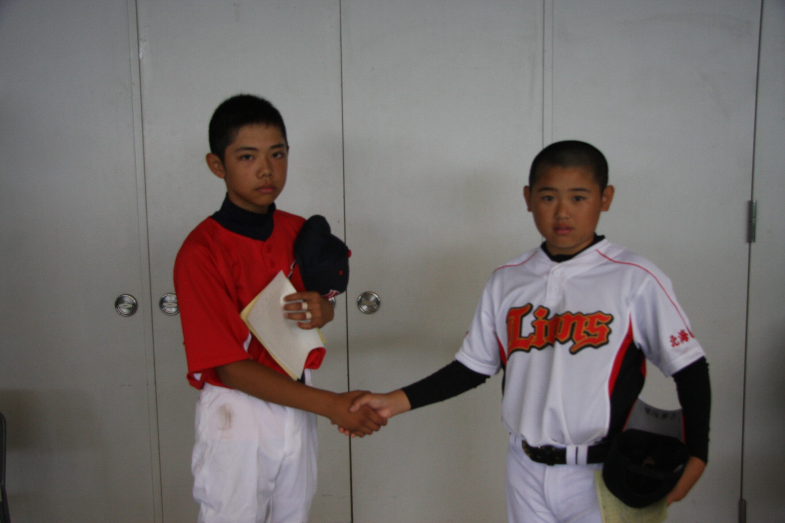 塩田(日高野球)と天内(札南)の両主将が試合前に握手