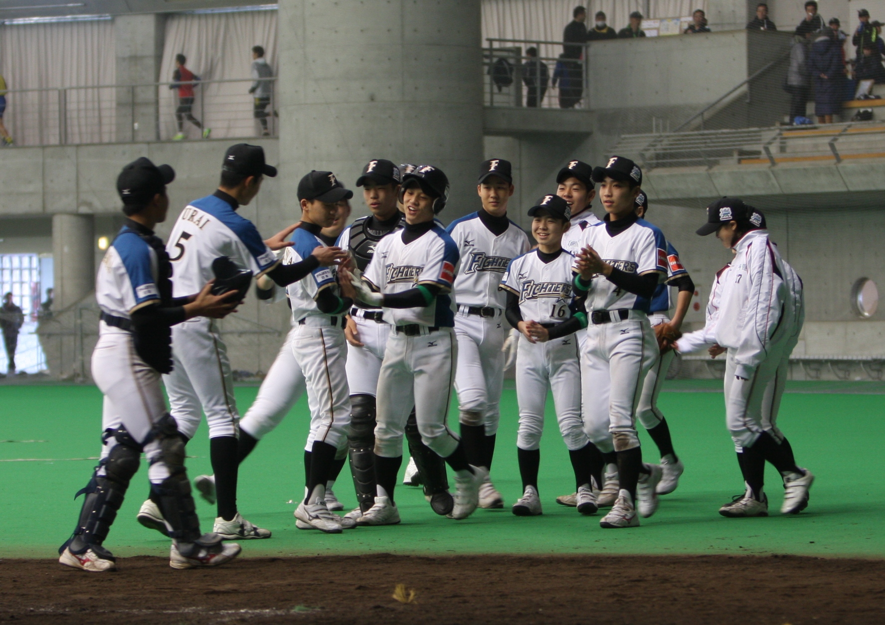 四回、本塁打でナインから祝福を受ける明田選手
