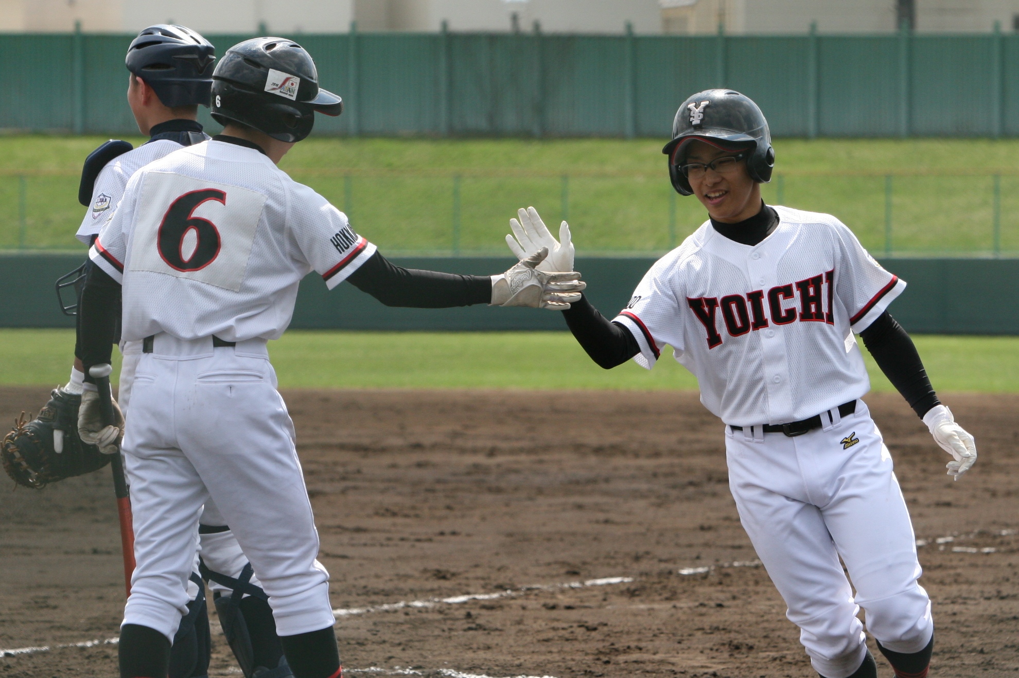 背番号6の岸部選手 とハイタッチする本塁打を放った鈴木選手