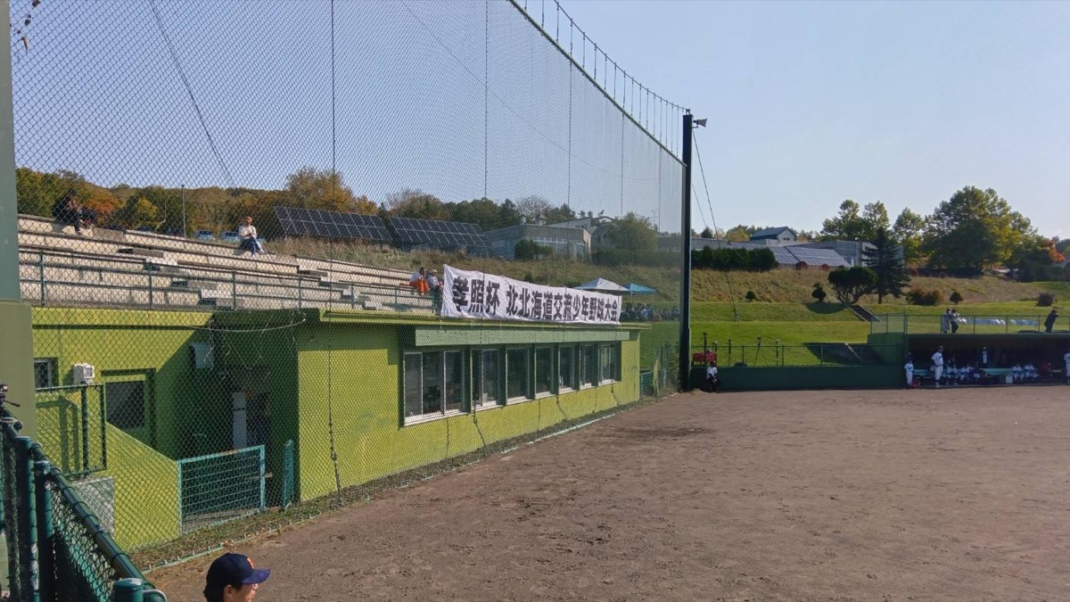 孝照杯北北海道交流少年野球大会の横断幕が掲げられた当麻球場